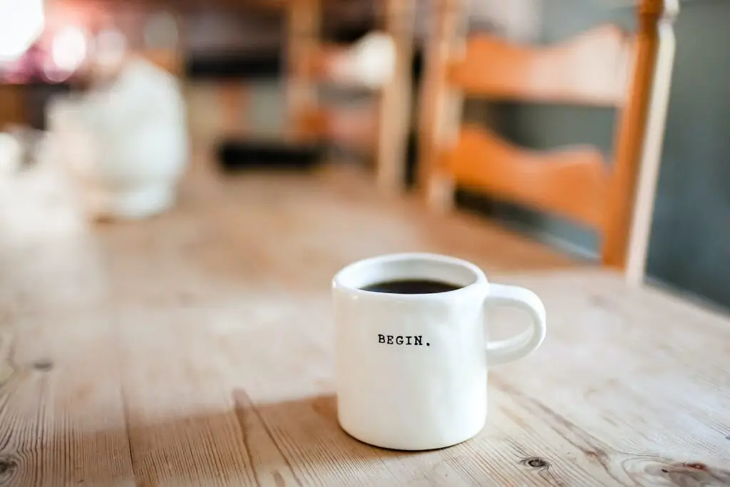 content creation - coffee mug on table with the words "begin"